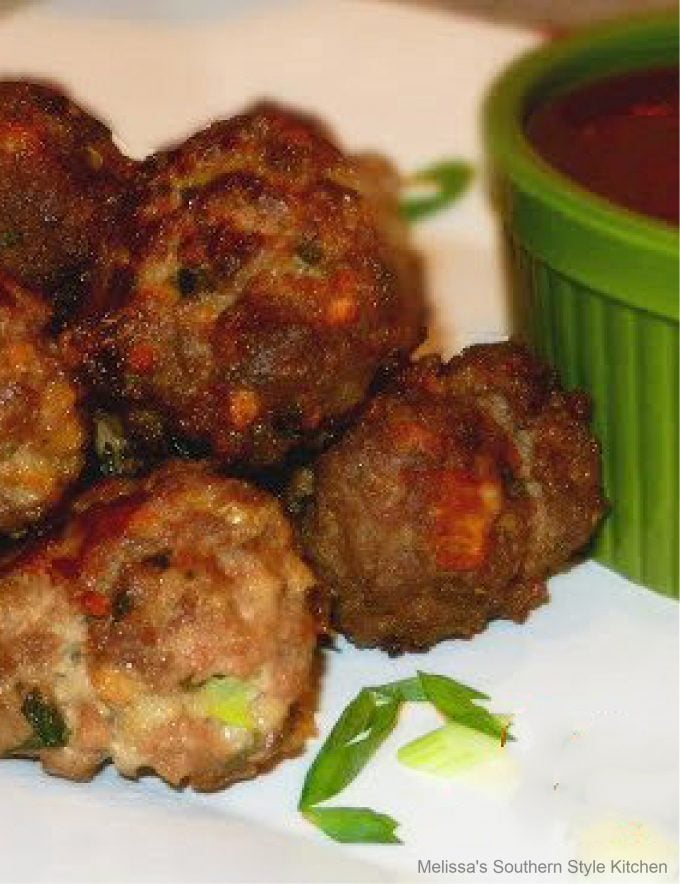 cooked meatballs on a white platter garnished with green onion