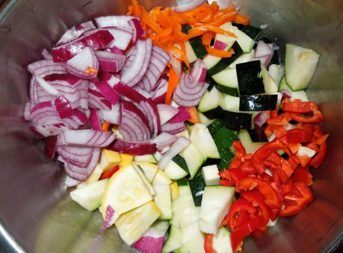 squash, zucchini, peppers and onion in mixing bowl