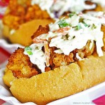 fried shrimp rolls topped with cole slaw on a white dish