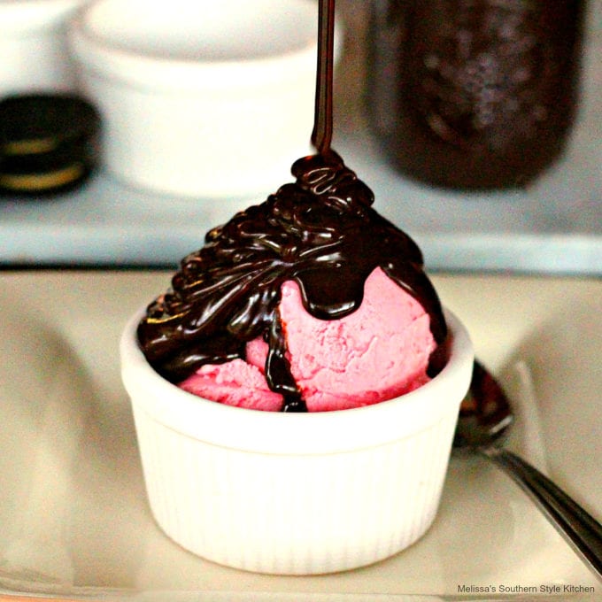 Strawberry ice cream in a bowl drizzled with hot fudge