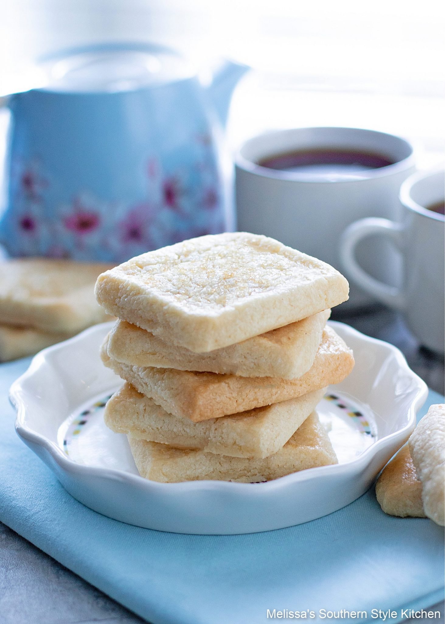 square shortbread cookies on a plate with coffee cups